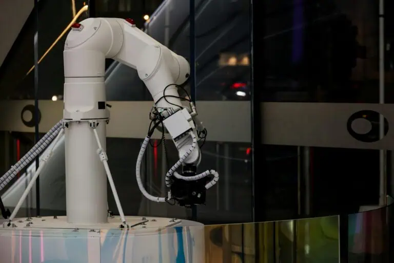 A white robotic arm with cables and a camera attached